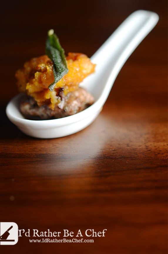 Butternut squash and sausage appetizer served in a small porcelain spoon