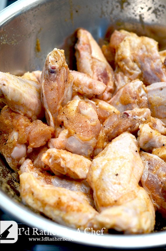 smoked wings recipe- wings getting coated with wet rub
