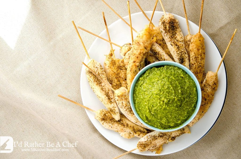 Oven baked chicken tenders with a pesto dipping sauce. Perfect for a party or an afternoon chillin and watching Netflix. This is a fast, easy baked chicken tenderloin recipe.
