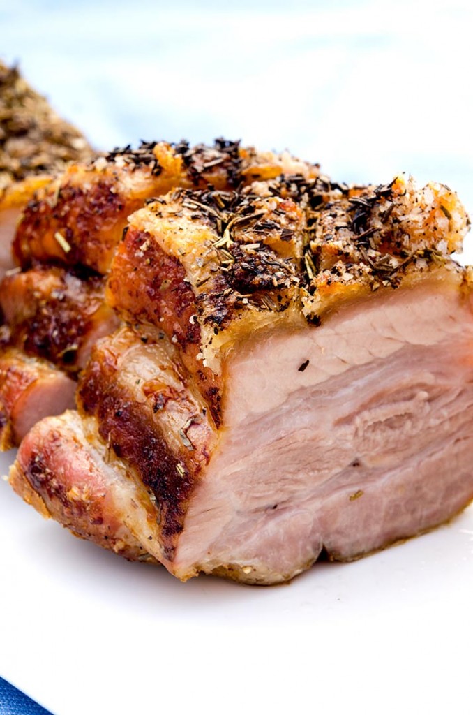 The sixth step for this crispy pork belly recipe is to add herbs de provence, baste and let cook for another hour.