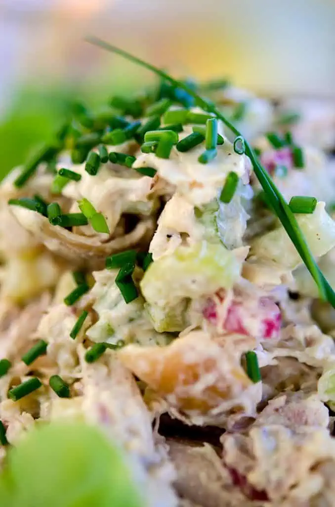 close up of rotisserie chicken salad topped with freshly chopped chives