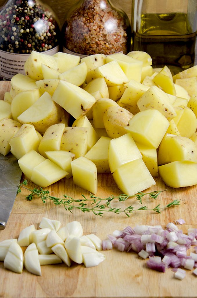 Gather up all the ingredients needed for the smashed potatoes. Chop the potatoes, garlic and shallots roughly.