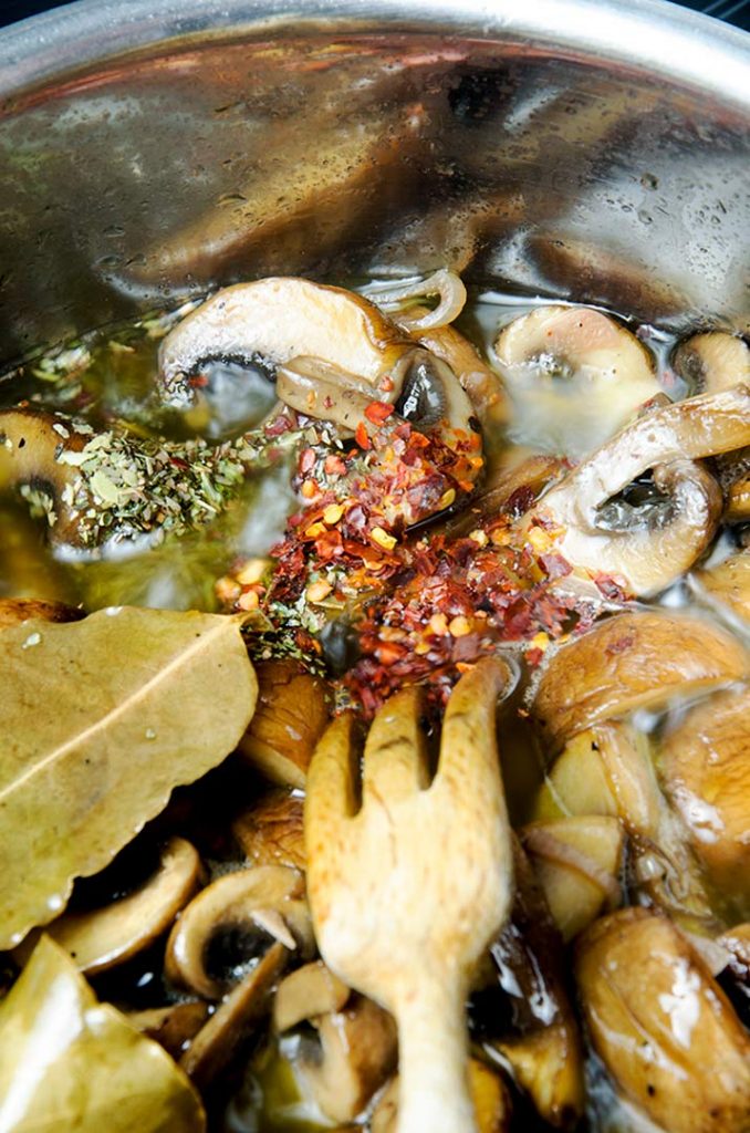 Adding red pepper flakes and dried oregano to marinated mushrooms really brings out the flavor.