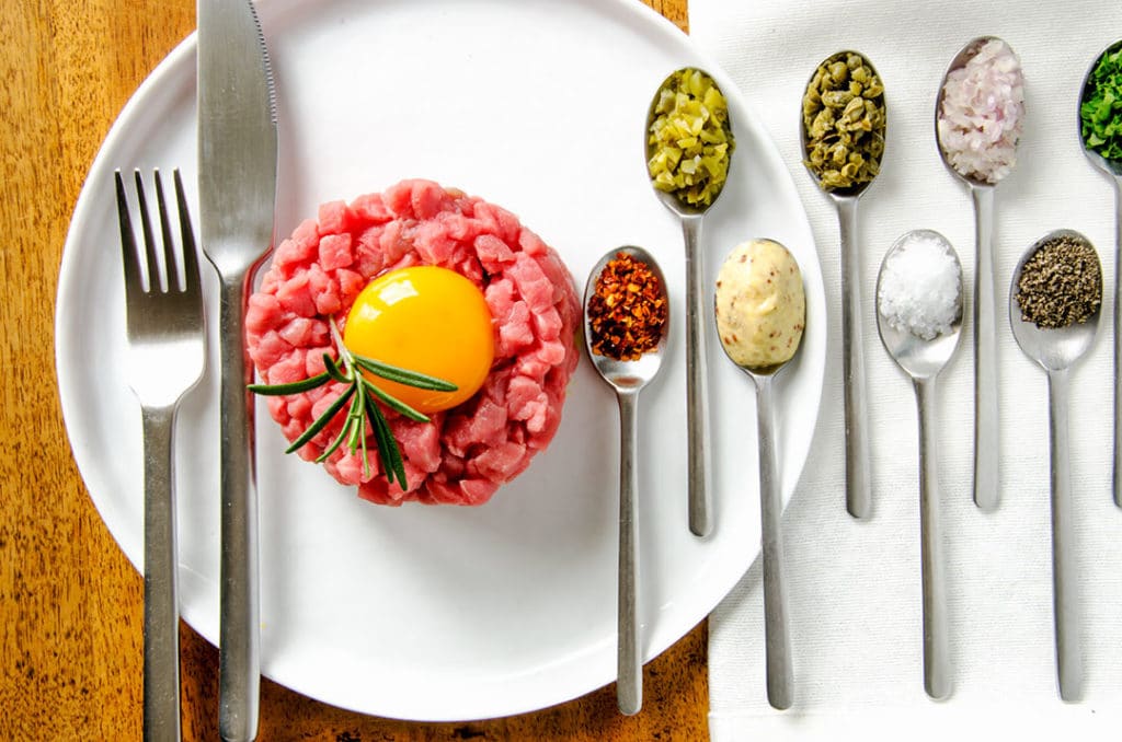 Steak tartare loves seasoning with mustard, capers, cornichon, salt, pepper, shallots, parsley and hot pepper flakes.