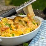 Roasted patty pan squash in a white baking dish, garnished with parsley and parmesan cheese.
