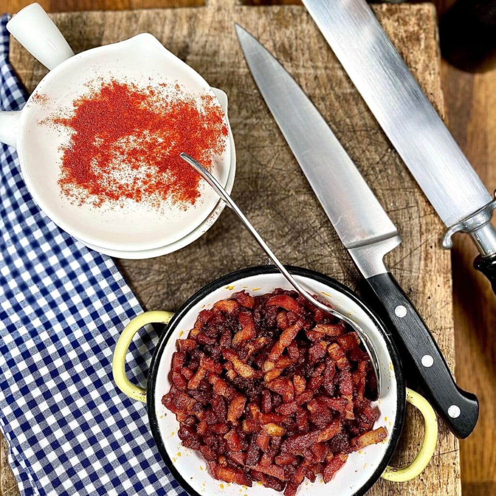 Dish full of homemade bacon bits on a blue plaid kitchen towel featured image