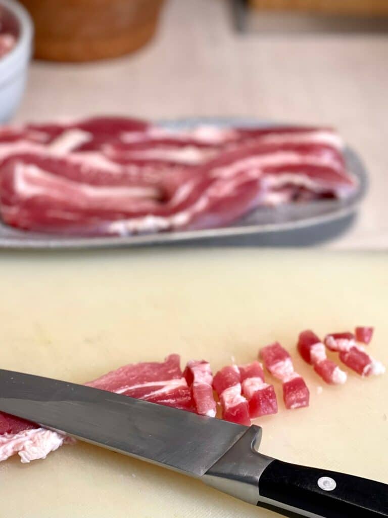 Bacon being chopped in preparation for bacon bits