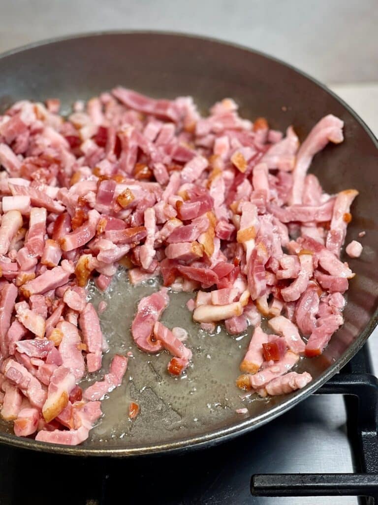 Chopped bacon sizzling in a pan for bacon bits