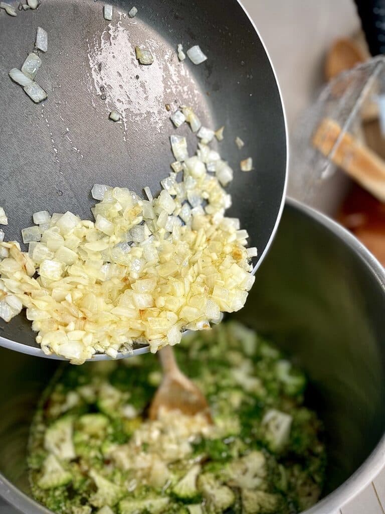 Adding the onion and garlic mix to the broccoli and stock pot.