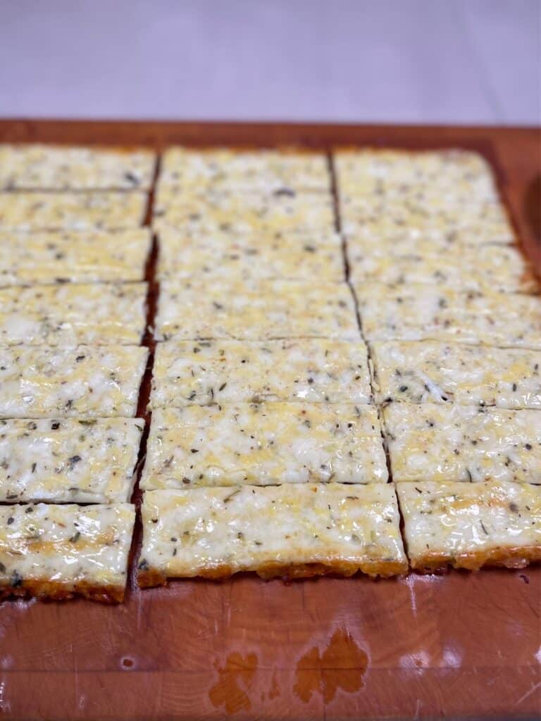 Cheesy mixture being cut into cheesy breadsticks