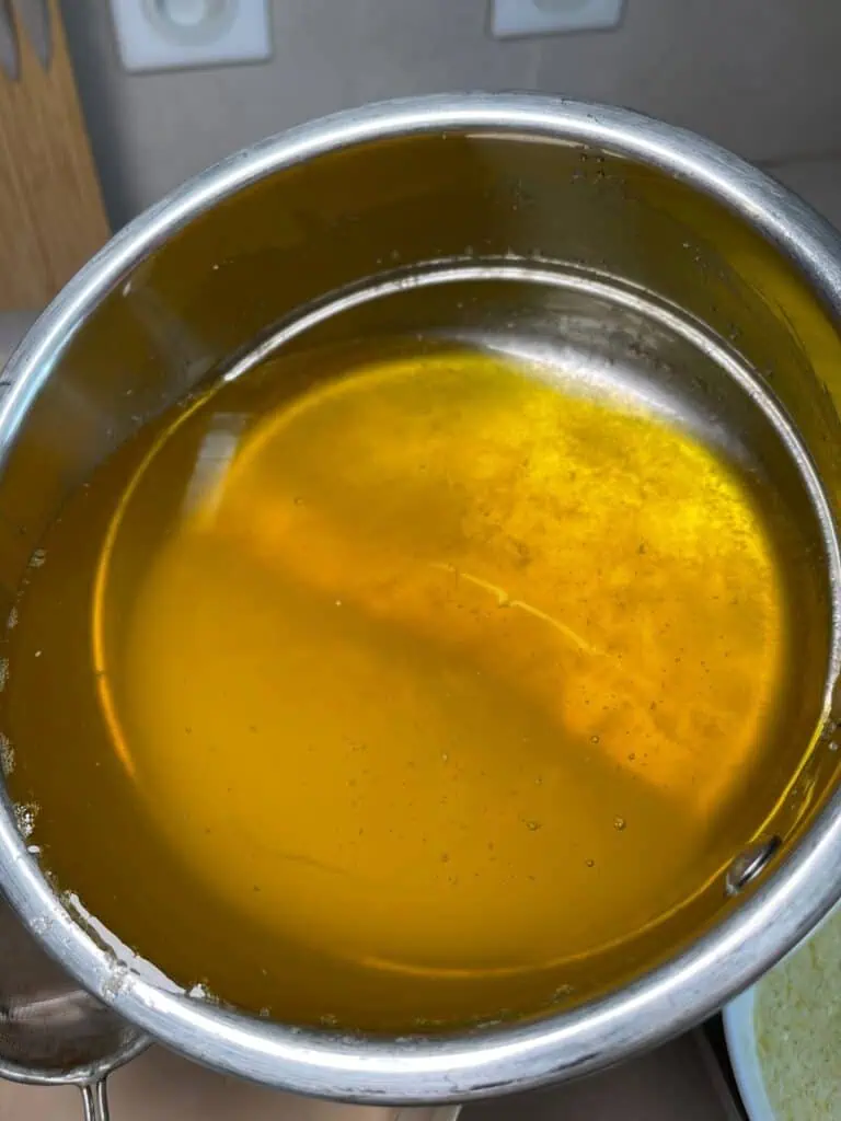 Showing the whey at the bottom of clarified butter in a double boiler