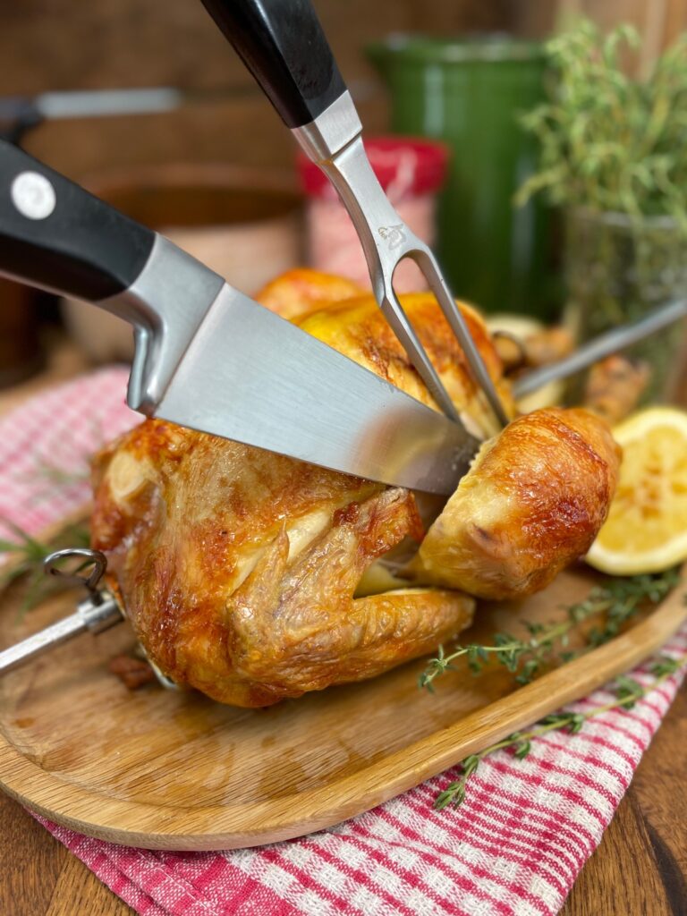 Rotisserie chicken being cut into on a platter