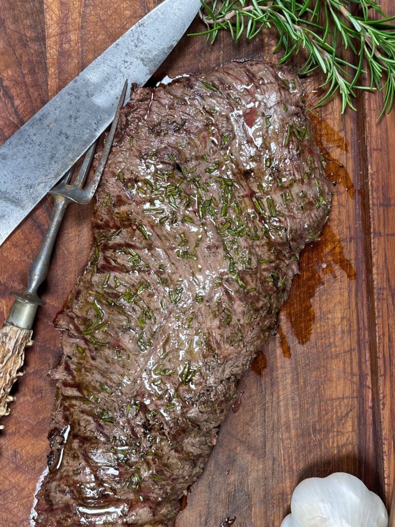 Steak marinade served with fresh herbs on a cutting board