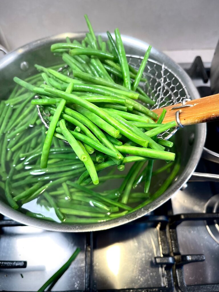 Rovers of green beans cooking in water for French haricots verts