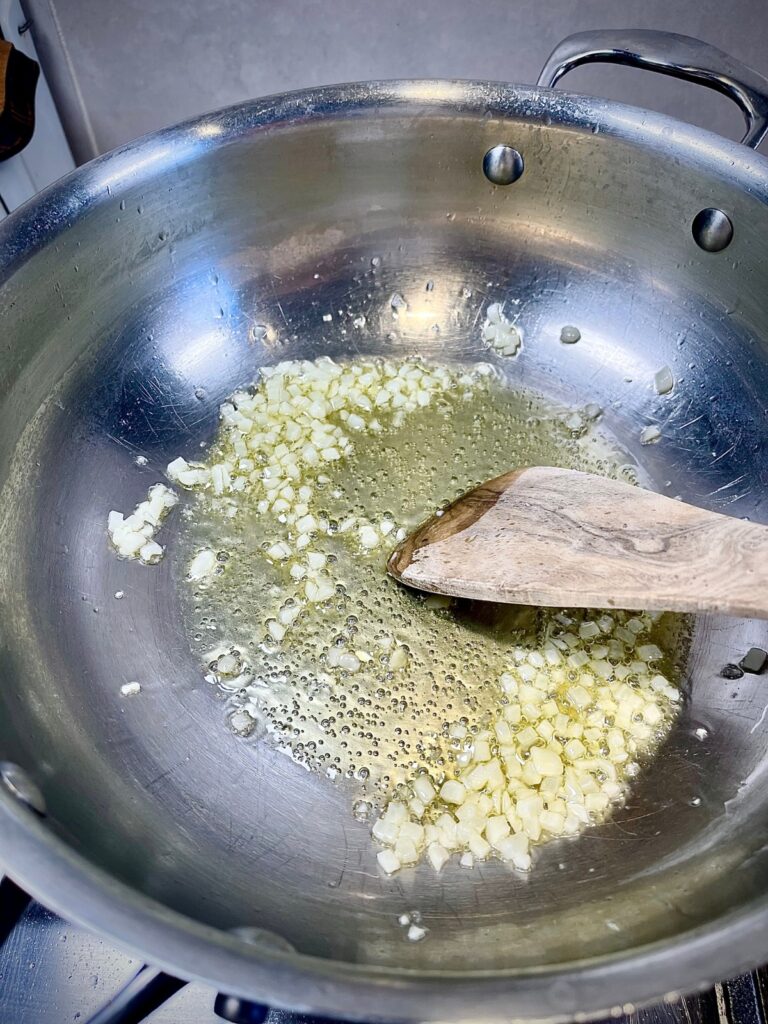 Garlic simmering in a pan for French haricots verts