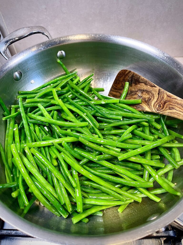 Green beans being added to the pan