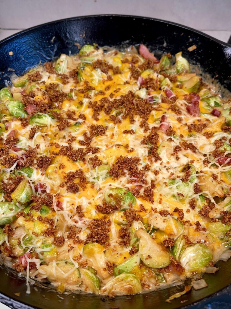 Cheesy brussel sprout casserole done cooking with spices being added
