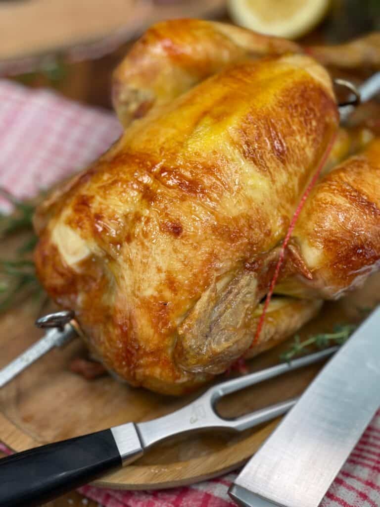 Rotisserie chicken on skewers on a cutting board