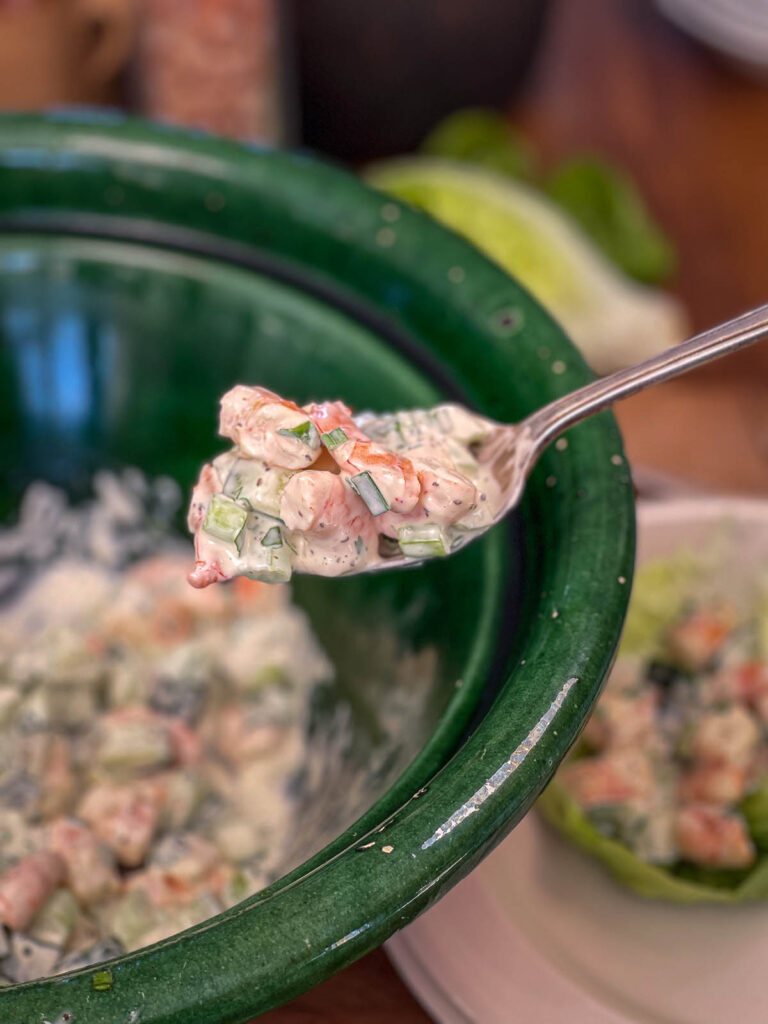Spoonful of keto shrimp salad suspended over the bowl