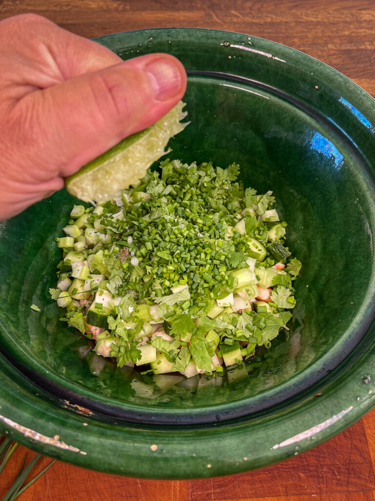 Ingredients being added to a bowl in preparation for shrimp salad