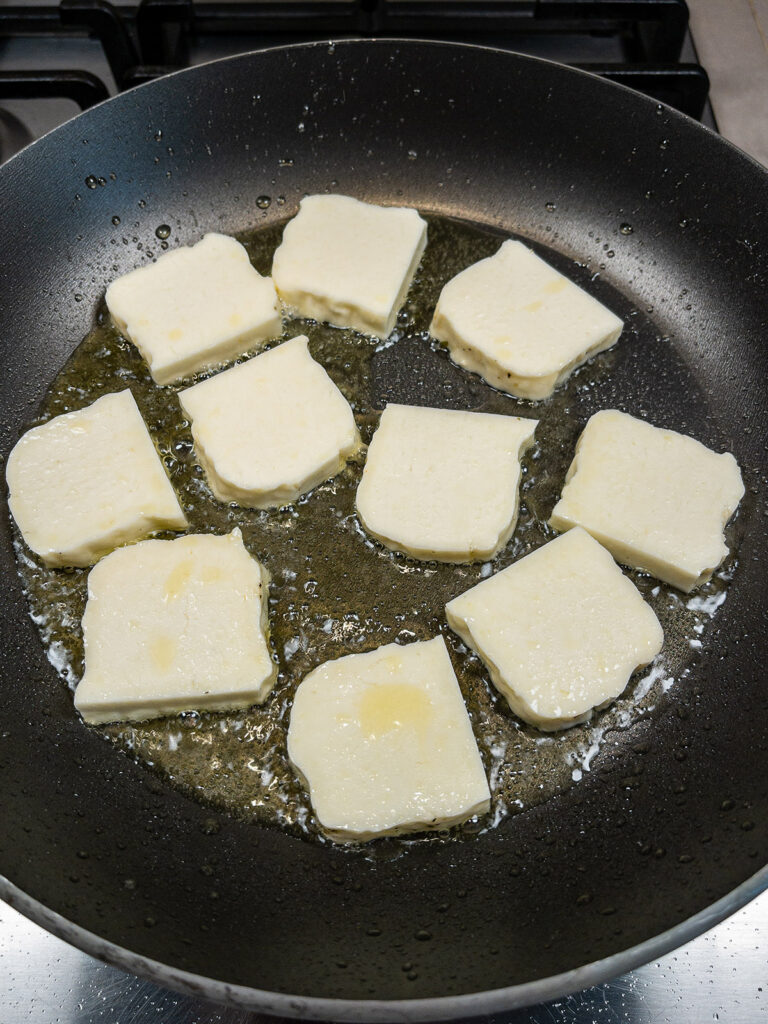Halloumi cheese searing in a pan