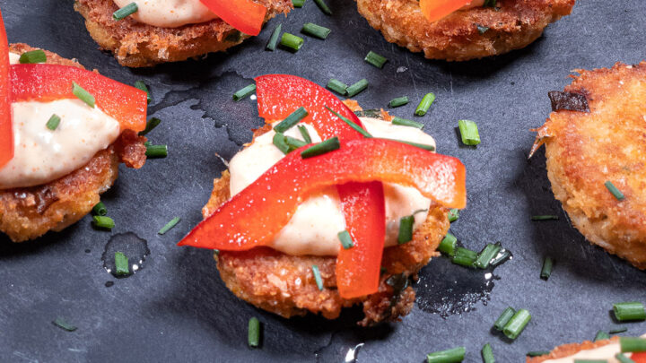Keto crab cakes on a platter topped with fresh herbs featured image