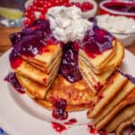 Plate of keto pancakes topped with blueberry sauce and whipped cream featured image
