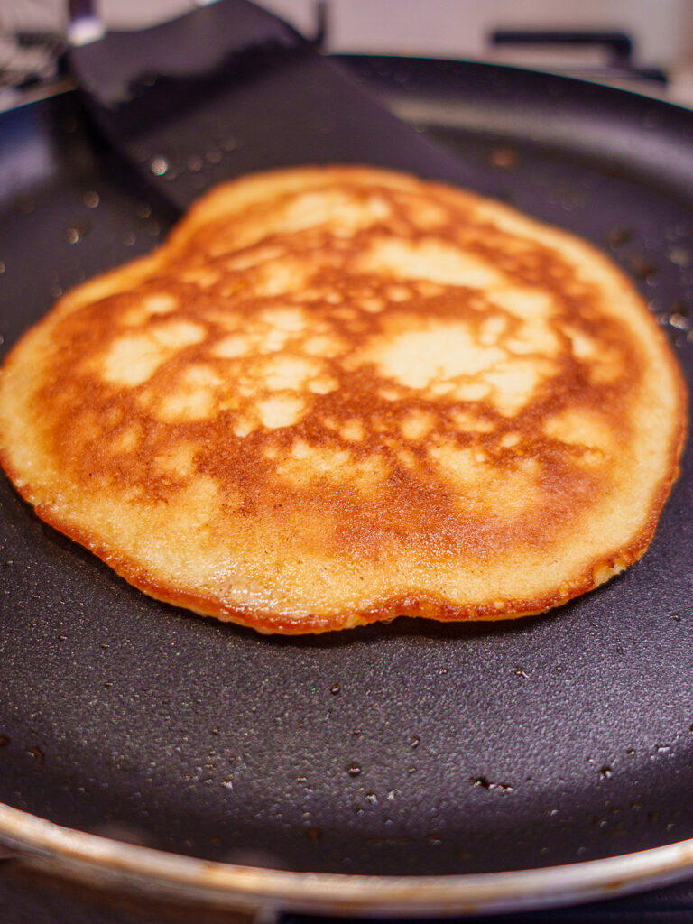 Keto pancake on a pan cooking