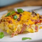 Plate of loaded cauliflower bake topped with fresh scallions