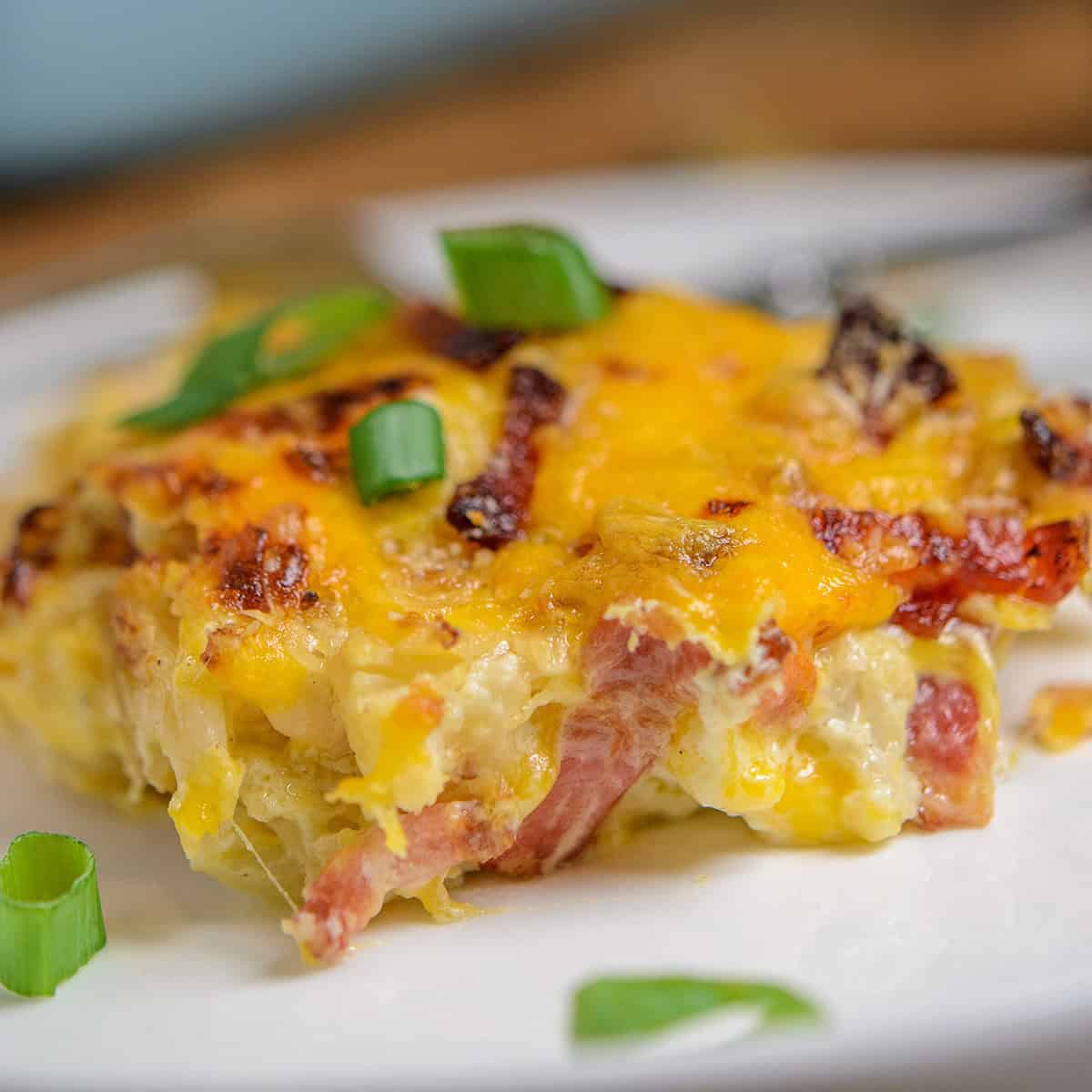 Plate of loaded cauliflower bake topped with fresh scallions