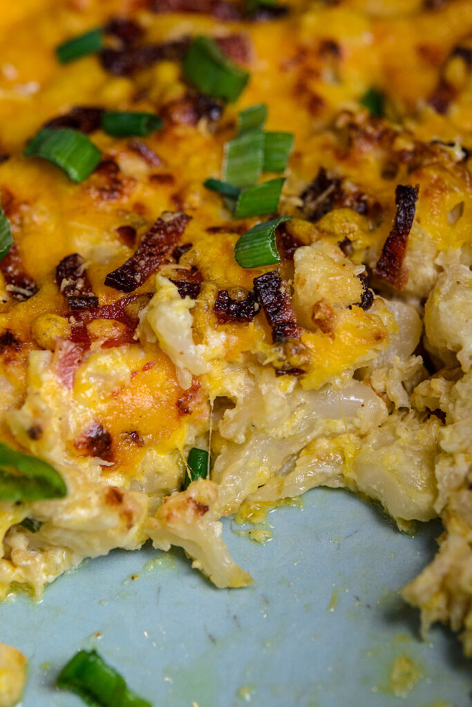 Close up of loaded cauliflower bake topped with scallions