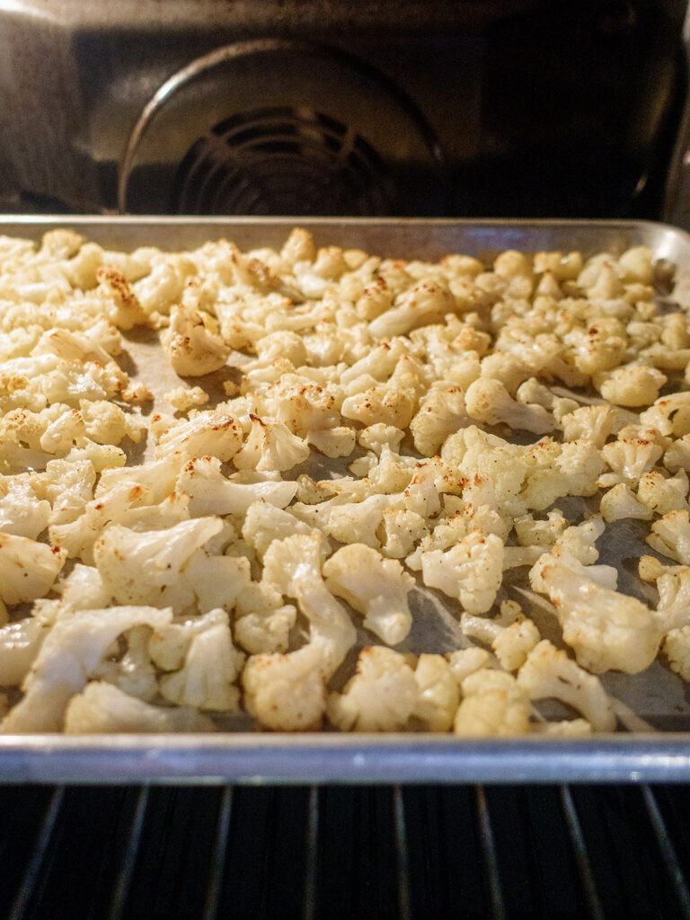 Tray of cauliflower in oven for loaded cauliflower bake