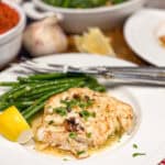 Pan seared cod served with green beans and fresh herbs on a plate