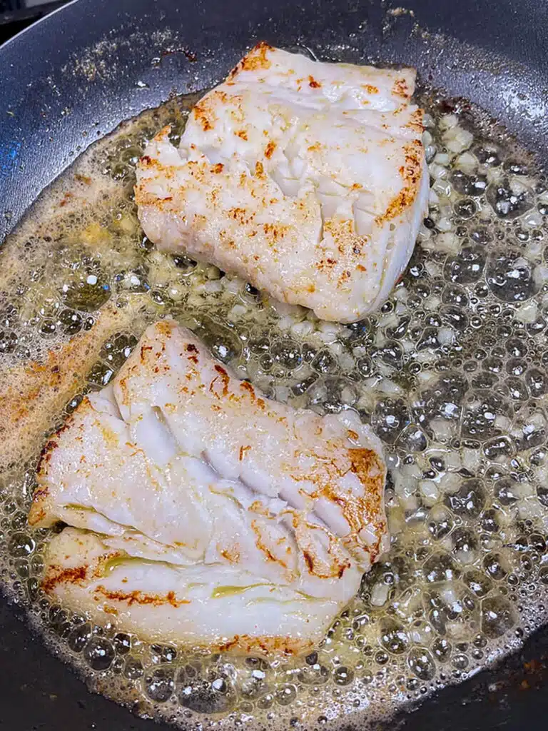 Cod cooking in a pan for pan seared cod