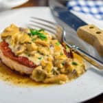 Plate-of-smothered-pork-chops-topped-with-minced-basil