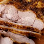 Close-up of sliced oven-roasted turkey breast showcasing tender, juicy layers and a crispy, seasoned crust.